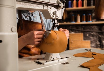 close-up-shoemaker-using-sewing-machine