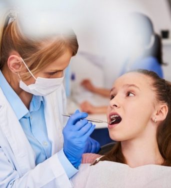 female-orthodontist-examining-child-s-teeth-1