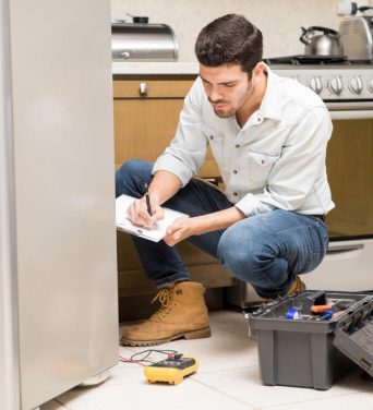 portrait-handsome-male-technician-doing-work-report-broken-fridge-home-kitchen